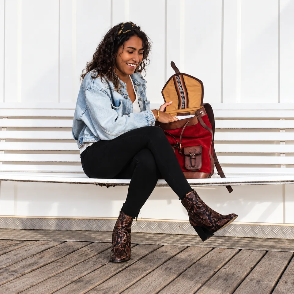 GABI Carmin, femme assise ouvrant son sac